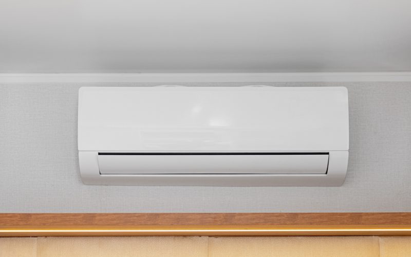 White Air Conditioner Mini Split Unit Mounted at Wall in Room